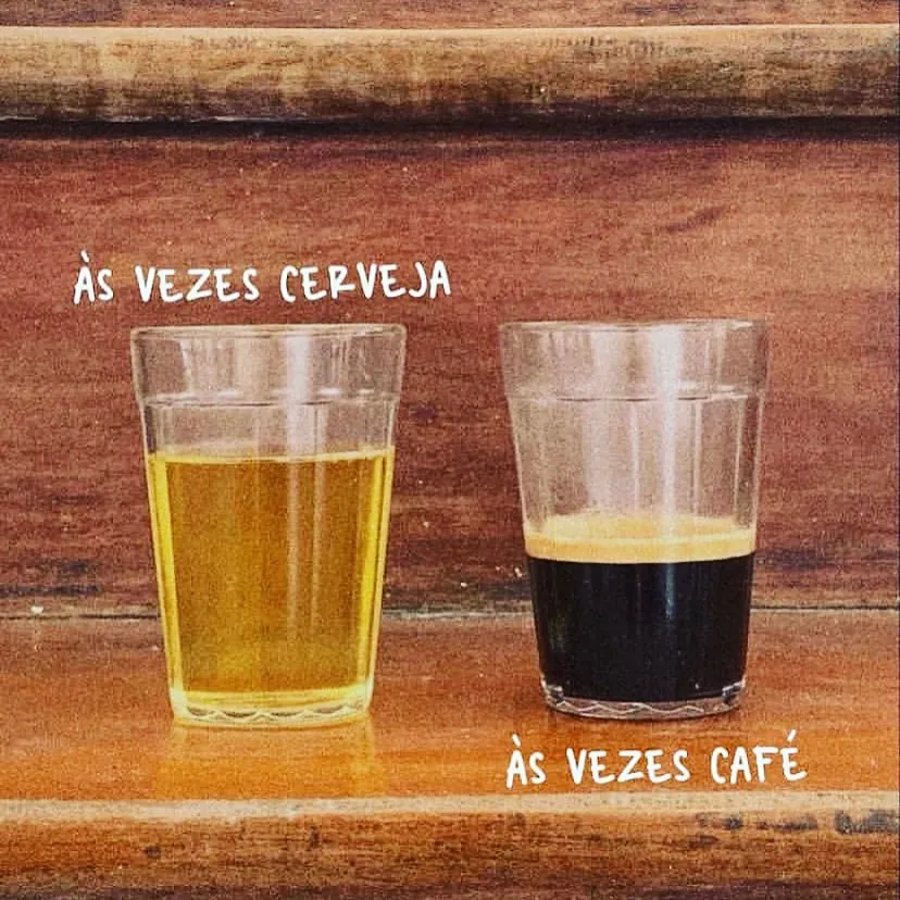 meme de às vezes café vira cerveja com dois copos sobre mesa de madeira, um com bebida clara e outro com café preto