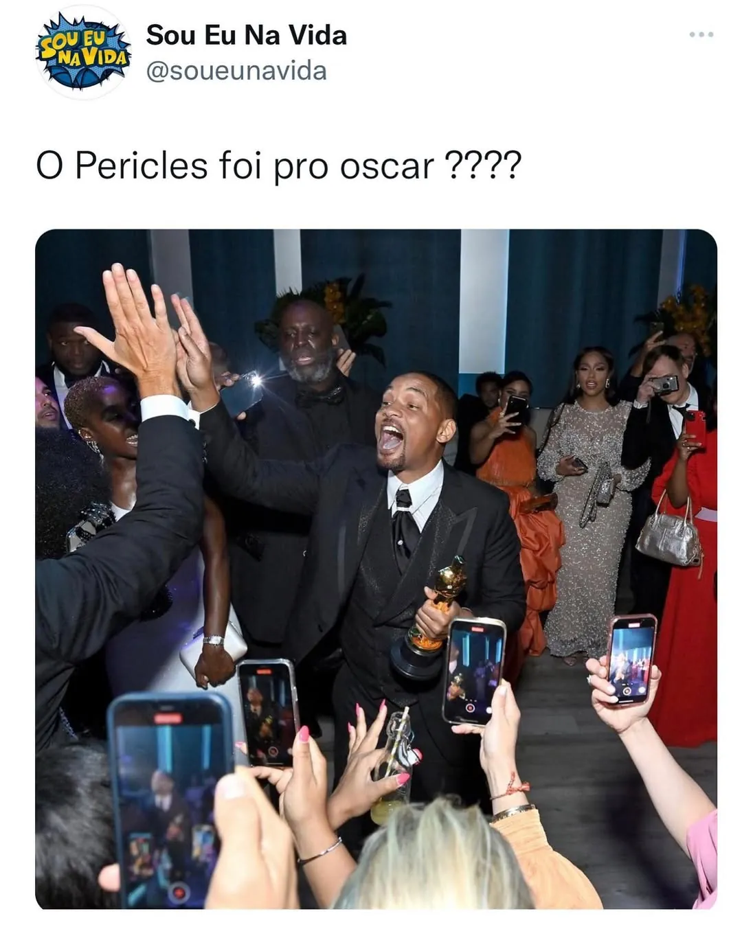 meme de Pericles no Oscar com pessoas filmando e ele segurando troféu em evento chique